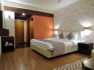 西姆拉西姆拉蜜月酒店的一间卧室,卧室内配有一张大床