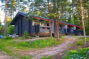 萨洛Isotalo Farm at enäjärvi lake的黑小屋,在树林里设有红色屋顶