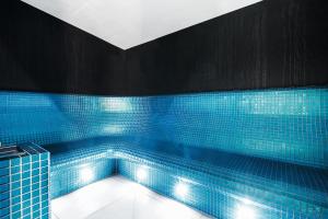 索波特Hotel Testa的蓝色瓷砖浴缸,配有灯光