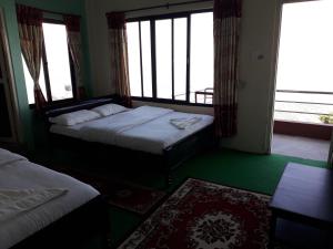 博卡拉Himalayan crown lodge的酒店客房设有两张床和窗户。