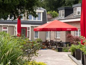 默伊德贝赫右居餐厅酒店的房屋前带红伞的庭院