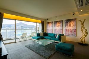 函馆函馆男爵俱乐部度假酒店的客厅配有蓝色的沙发和玻璃桌
