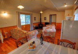 BallandeanAccommodation Creek Cottages & Sundown View Suites的客厅配有桌椅和冰箱。