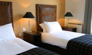 埃尔金Eight Acres Hotel的酒店客房设有两张床和两盏灯。
