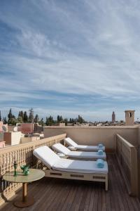 马拉喀什72 Riad的阳台配有两张床和一张屋顶桌子。