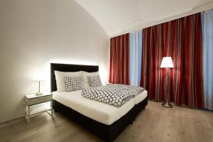 维也纳Pension am Wienfluss的一间卧室配有床和红色窗帘