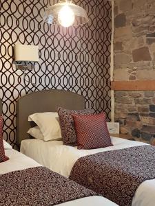 科克茅斯Croft Guesthouse的一间卧室设有两张床和砖墙