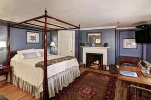 夏洛茨维尔200南大街旅馆的一间卧室设有一张天蓬床和一个壁炉