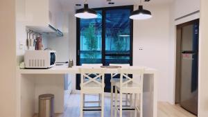 台北Lienmei 月租房的厨房配有白色的柜台和凳子