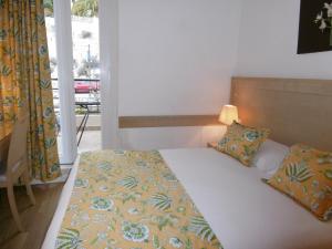 滨海自由城弗罗尔酒店的一间卧室设有一张床和一个窗口