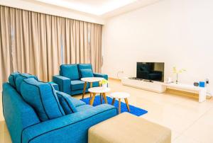 新山4-Bedrm ensuite family friendly house near Aeon Bukit Indah的客厅配有蓝色的沙发和两把椅子