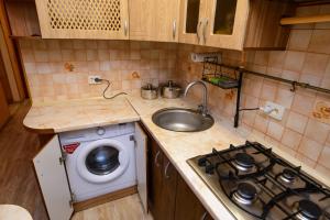 切尔卡瑟Апартаменты Deluxe的一个带水槽和洗衣机的小厨房