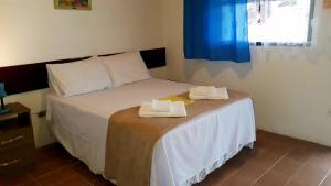卡纳内亚Pousada Via Maria的一间卧室配有一张床,上面有两条毛巾