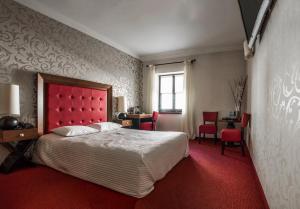卢布林香草酒店的一间卧室配有一张红色床头板和红色地毯的床