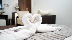 尼赖吉哈佐Hotel Írisz的两条毛巾,形状像天鹅,坐在床上