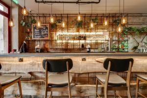 波尔图Selina Porto的餐厅设有配备椅子和灯的酒吧