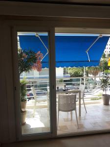 戛纳Palm beach Cannes Azur的配有桌椅和蓝伞的庭院门