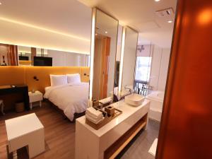 首尔格拉莫斯酒店的一间带一张床的卧室和一间带镜子的浴室