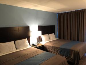 长滩长滩酒店的酒店客房,设有两张床和一盏灯