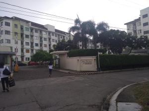 圣罗莎Spacious Studio unit beside Enchanted Kingdom at Santa Rosa City Laguna的走在建筑物旁边的街道上的女人