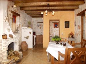 凯里翁雷沃拉传统石头别墅和公寓酒店的厨房配有白色的桌子和壁炉。