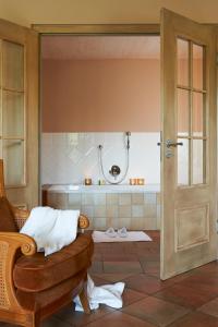 林道维里诺酒店的带淋浴、椅子和浴缸的浴室