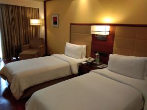 古尔冈古尔冈丽柏酒店的酒店客房,配有两张床和椅子