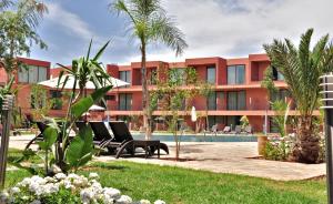 马拉喀什Rawabi Hotel Marrakech & Spa的一个带游泳池和棕榈树的度假村