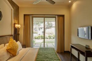 罗纳瓦拉Rhythm Lonavala - An All Suite Resort的一间卧室设有一张床和一个滑动玻璃门