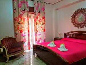 Leonforte24 Cannoli的卧室配有粉红色的床和椅子