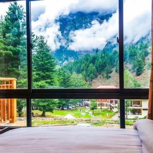 GhumlaTrout Lodges的卧室的山景窗户