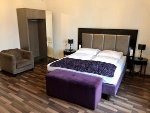 维也纳斯科顿托男爵膳食公寓酒店的一间卧室配有一张大床和紫色的搁脚凳