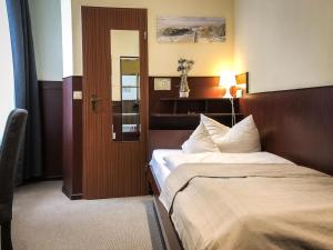 吕贝克汉萨酒店的一间酒店客房,设有一张床和一扇门