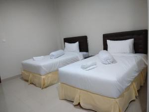 鲁滕Victory Hotel的配有2张床的带白色床单和枕头的客房