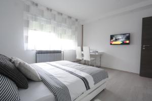 大戈里察Imperium Rooms Zagreb Airport的一间卧室配有一张床、一张桌子和一台电视