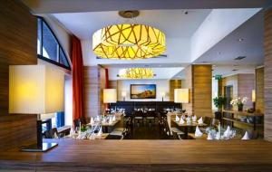 吕贝克吕贝克H + 酒店的一间带桌椅和吊灯的餐厅