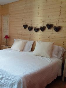 布兰兹佩德雷蒂酒店的一间卧室配有一张带白色枕头的床和木墙