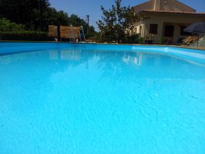 蒙特格里多尔福芬尼斯住宿加早餐旅馆的大型蓝色游泳池,里面设有长凳
