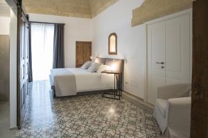 马泰拉Palazzo Montemurro的一间卧室配有一张床、一张桌子和一个窗户。