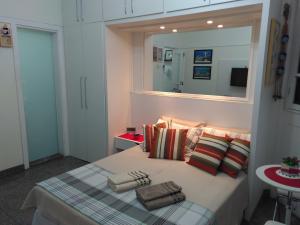 里约热内卢Charmoso Studio Ipanema的一间卧室配有带枕头和镜子的床