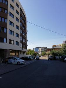 雅西Kolonaki Domus Apartment的停车场,停车场有汽车停在大楼旁边