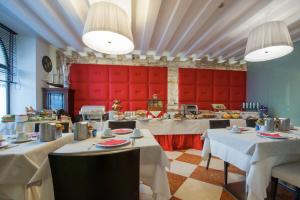维罗纳Hotel Bologna ***S的一间设有白色桌子和红色摊位的餐厅