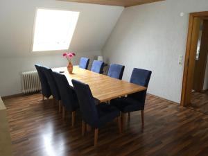 哈伦贝格Haus Nova am Bollerberg的一间带木桌和蓝色椅子的用餐室