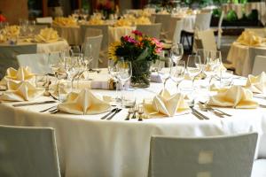 乌尔齐尼Hotel Ajana的一张带白色桌布、餐巾纸和酒杯的桌子