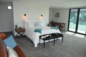 怀卡奈157 Field Way Luxury Lodge的卧室配有一张白色的大床和一张桌子
