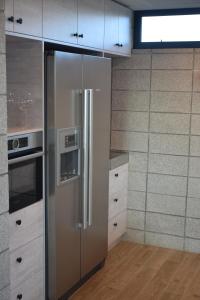 怀卡奈157 Field Way Luxury Lodge的一间厨房内的不锈钢冰箱,厨房内有白色的橱柜