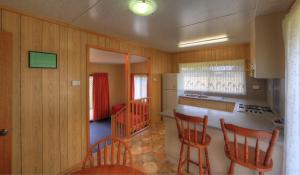 KelsoBIG4 Kelso Sands Holiday & Native Wildlife Park的厨房设有木墙、木椅和柜台。