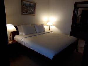 吉隆坡Bintang Apartment Times Square KL的卧室配有带两盏灯的白色床