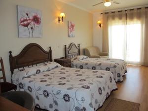 米兰达·杜·杜罗弗洛尔杜罗酒店的一间卧室配有两张带白色和黑色床单的床
