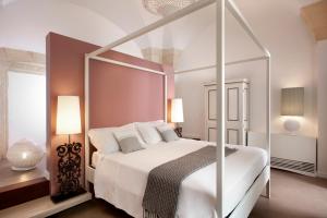 莱切曼塔特鲁尔酒店的白色卧室配有带白色枕头的天蓬床